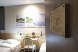 A hotel room with a bed, a chair, a sink, and a wall-mounted artwork. - Foresttel.bkk (Bangkok)