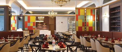 A restaurant with checkered flooring, multiple dining tables, and booths.