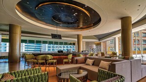 A modern lobby with a central seating area, a bar, and large windows offering views of the cityscape. - Ethiopian Skylight Hotel (Addis Ababa)