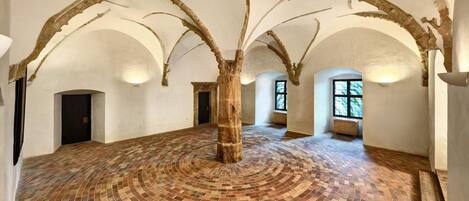 A spacious hall with a circular brick floor and arched ceilings.