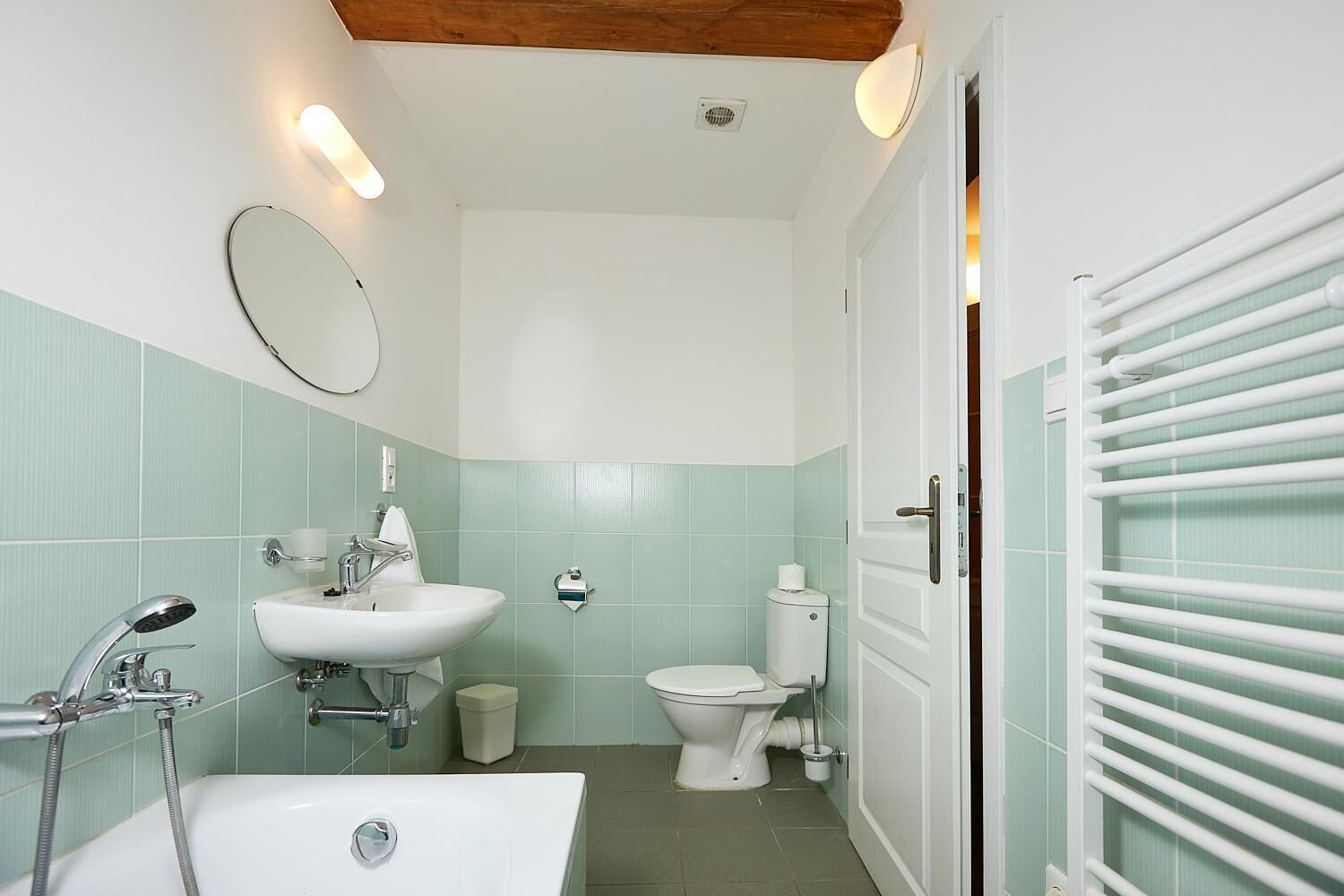 A compact bathroom with a sink, toilet, and bathtub.
