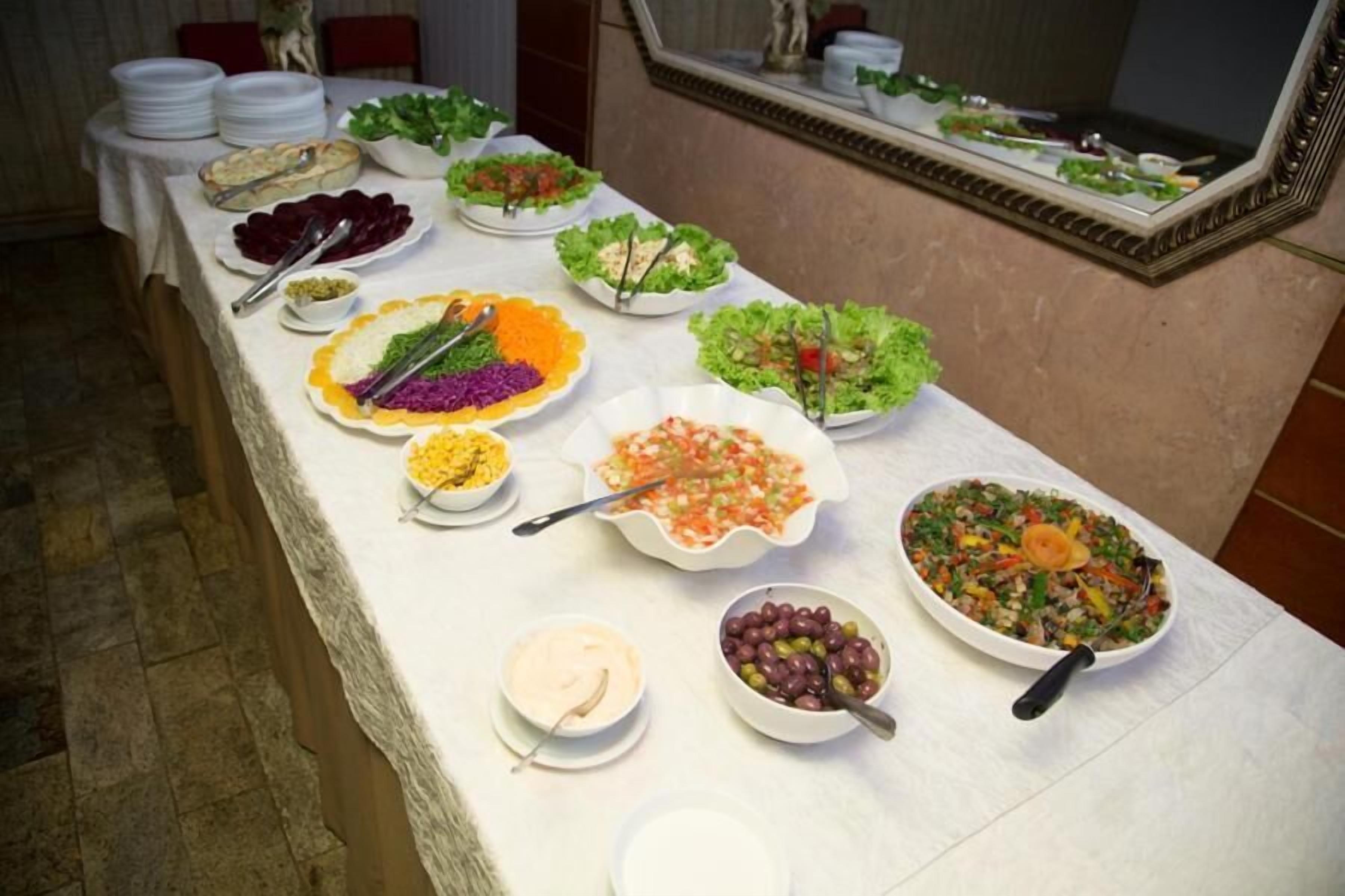 Uma mesa de buffet com diversos pratos e recipientes de comida.