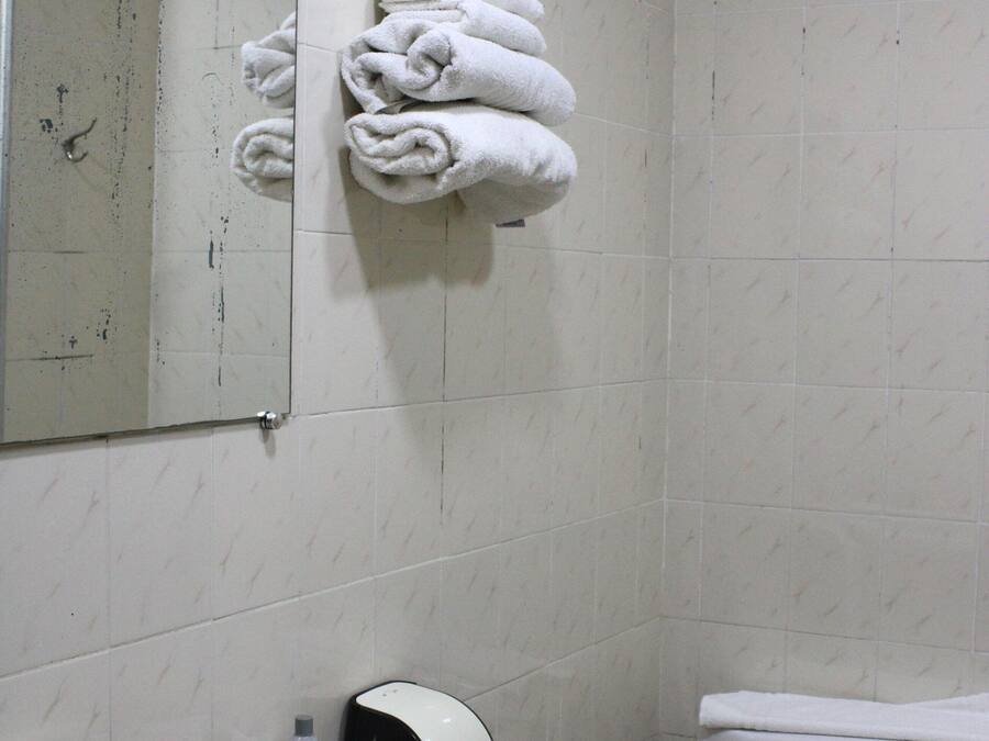 Un baño con lavamanos, inodoro y espejo.