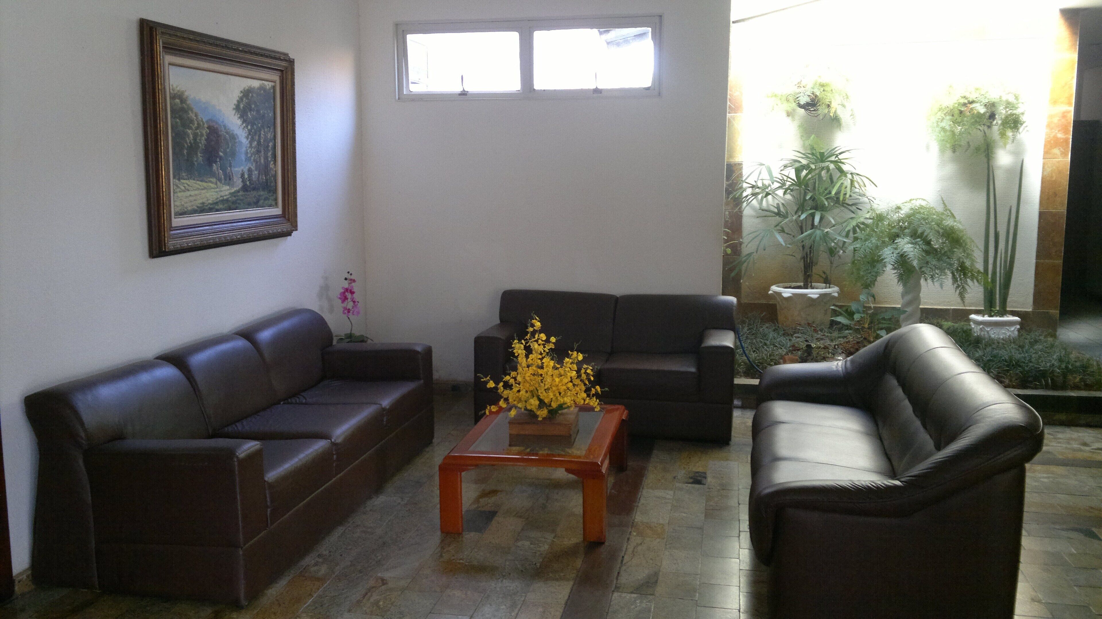 A living room with two sofas, a coffee table, and a painting on the wall.