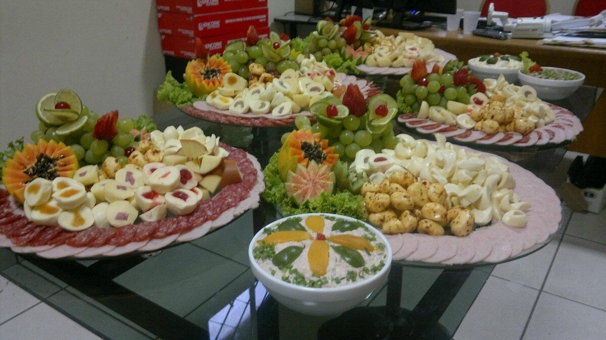 A table with various food platters, including fruits, cheeses, and other snacks.