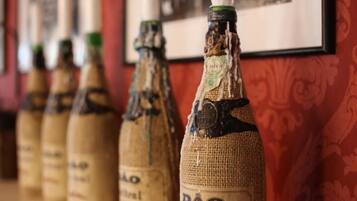 A row of bottles with labels, some with visible damage, against a patterned wall.
