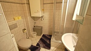 A bathroom with a toilet, bidet, shower, and sink. - Apartments Kreuzgasse (Zell am See)