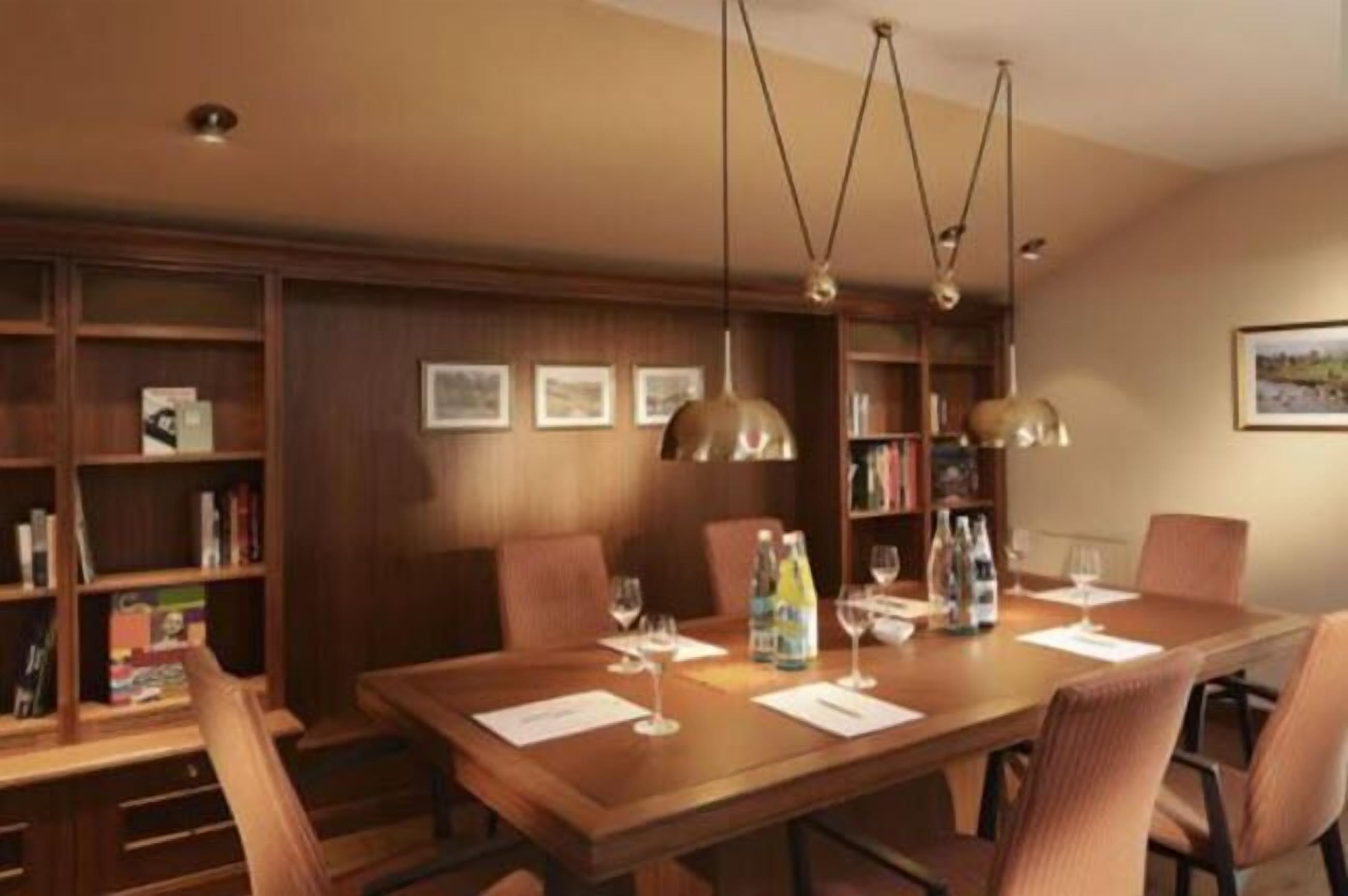 A conference room with a long table, chairs, and bookshelves.
