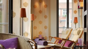 A room with two reclining chairs, a small table with a drink, and a view of the outside. - Die Sonne Frankenberg (Frankenberg)