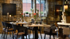 A restaurant interior with stone walls, wooden tables, and chairs. - Die Sonne Frankenberg (Frankenberg)