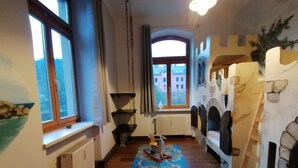 A narrow hallway with wooden flooring, a window on the left, a radiator, and a window on the right. - Pension Bomätscher (Koenigstein)