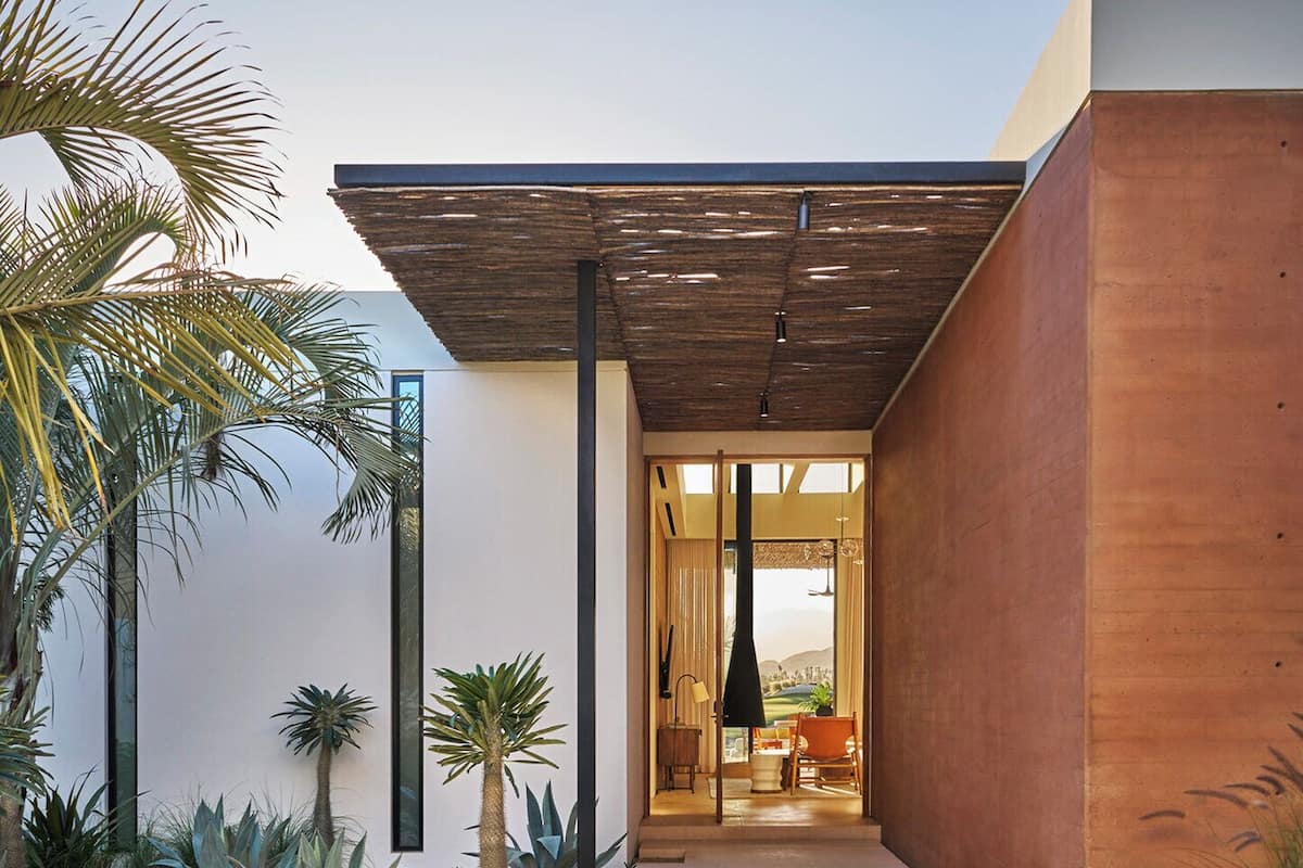 A modern house with a patio, a pool, and a view of the landscape.