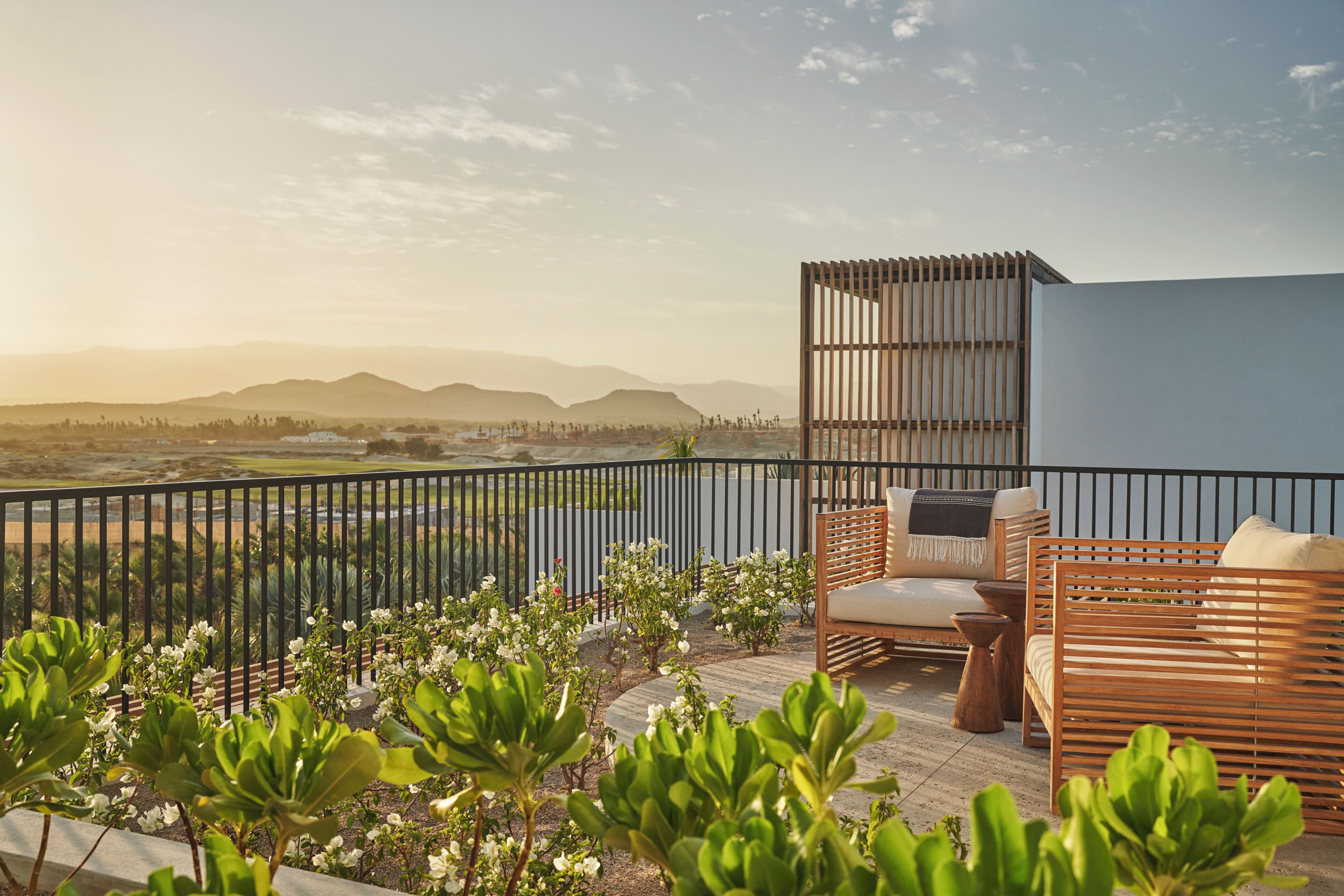 Un balcón con mobiliario exterior, vistas del paisaje y una barandilla.