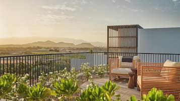 Un balcón con mobiliario exterior, vistas del paisaje y una barandilla.