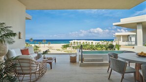 A modern outdoor seating area with a view of the beach and ocean.