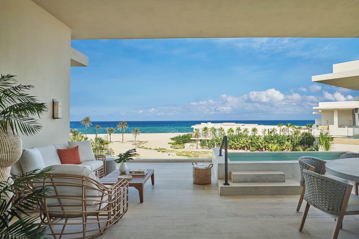 A modern outdoor seating area with a view of the beach and ocean.