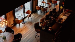 A restaurant with wooden flooring, round tables, and cushioned chairs. - hotel friends Zeche Zollverein - Essen (Essen)