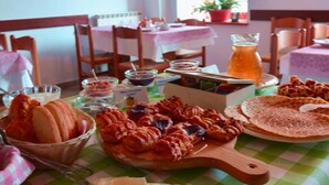 Un coin repas avec une nappe à carreaux, divers plats et une décoration rustique comprenant des poutres en bois et une fenêtre.