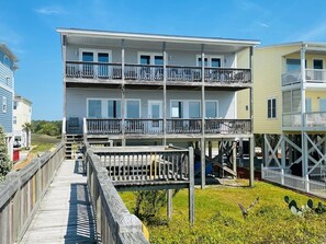A multi-story building with balconies, a wooden deck, and a clear view of the surrounding area.
