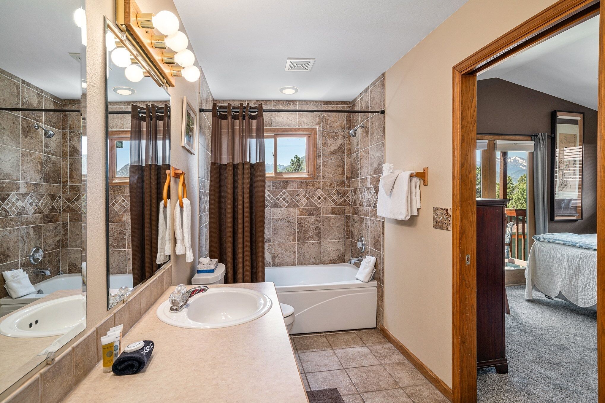 A bathroom with a bathtub, a sink, a mirror, and a shower.