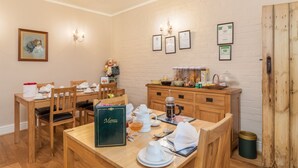 A dining area with wooden furniture, a menu on the table, and various kitchen items. - Stilworth House (York)