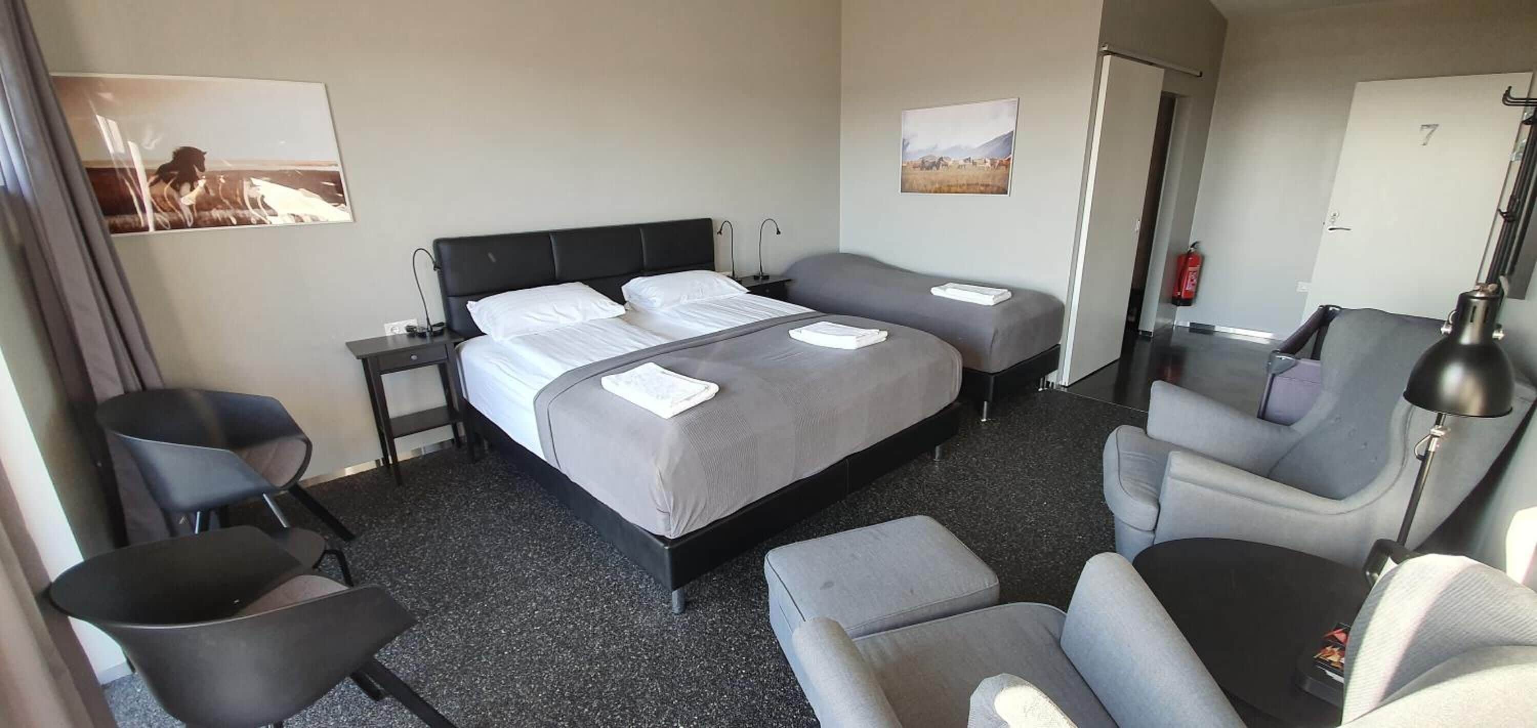 Een hotelkamer met een bed, twee nachtkastjes, een bureau, een stoel en een lamp.