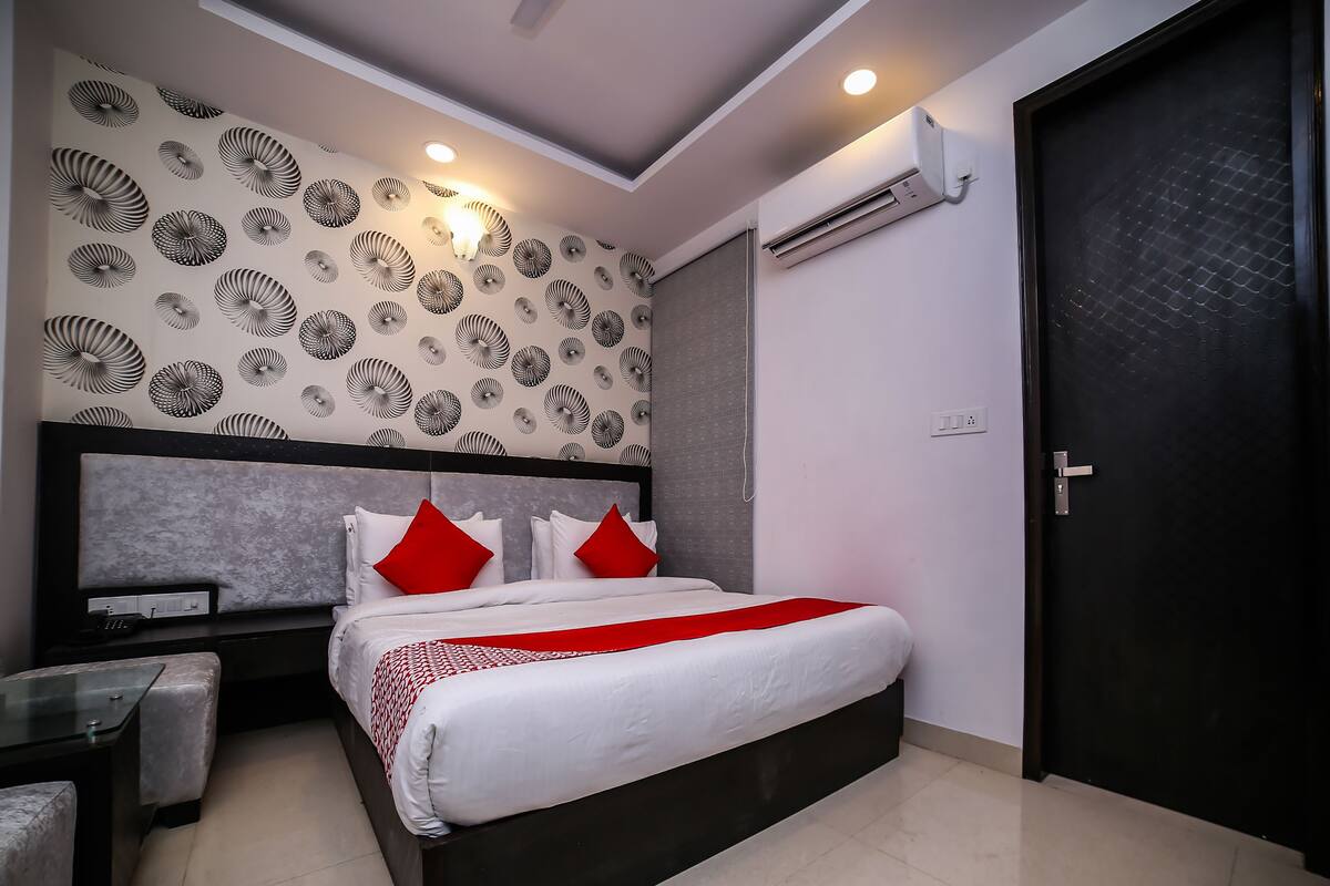 Une chambre moderne avec un lit, des tables de chevet et un appareil de climatisation.