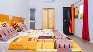 Une chambre à coucher avec un lit, une armoire, une porte et une fenêtre avec des rideaux.
