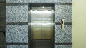Un ascenseur à l’intérieur métallique, doté d’un écran numérique affichant le chiffre 4.