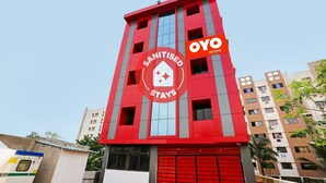 Een rood gebouw met een bord waarop staat 'Sanitised Stays' en 'Oyo Rooms'.
