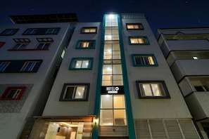 A hotel building with multiple floors, a central entrance, and a sign indicating it is a hotel.