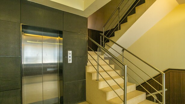 An elevator and a staircase with metal railings.