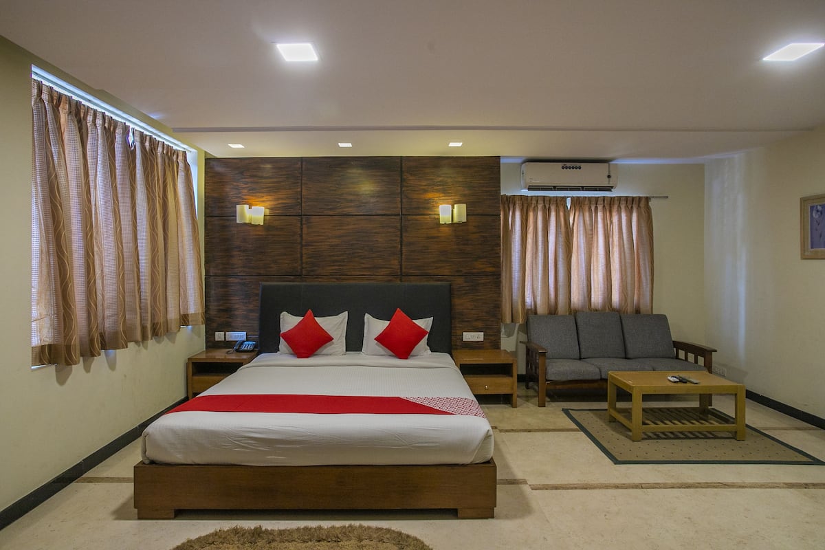 Une chambre à coucher comprenant un lit, des tables de chevet, un canapé, une table basse et un appareil de climatisation.