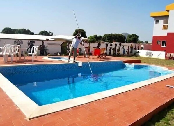 A swimming pool with a person cleaning it.