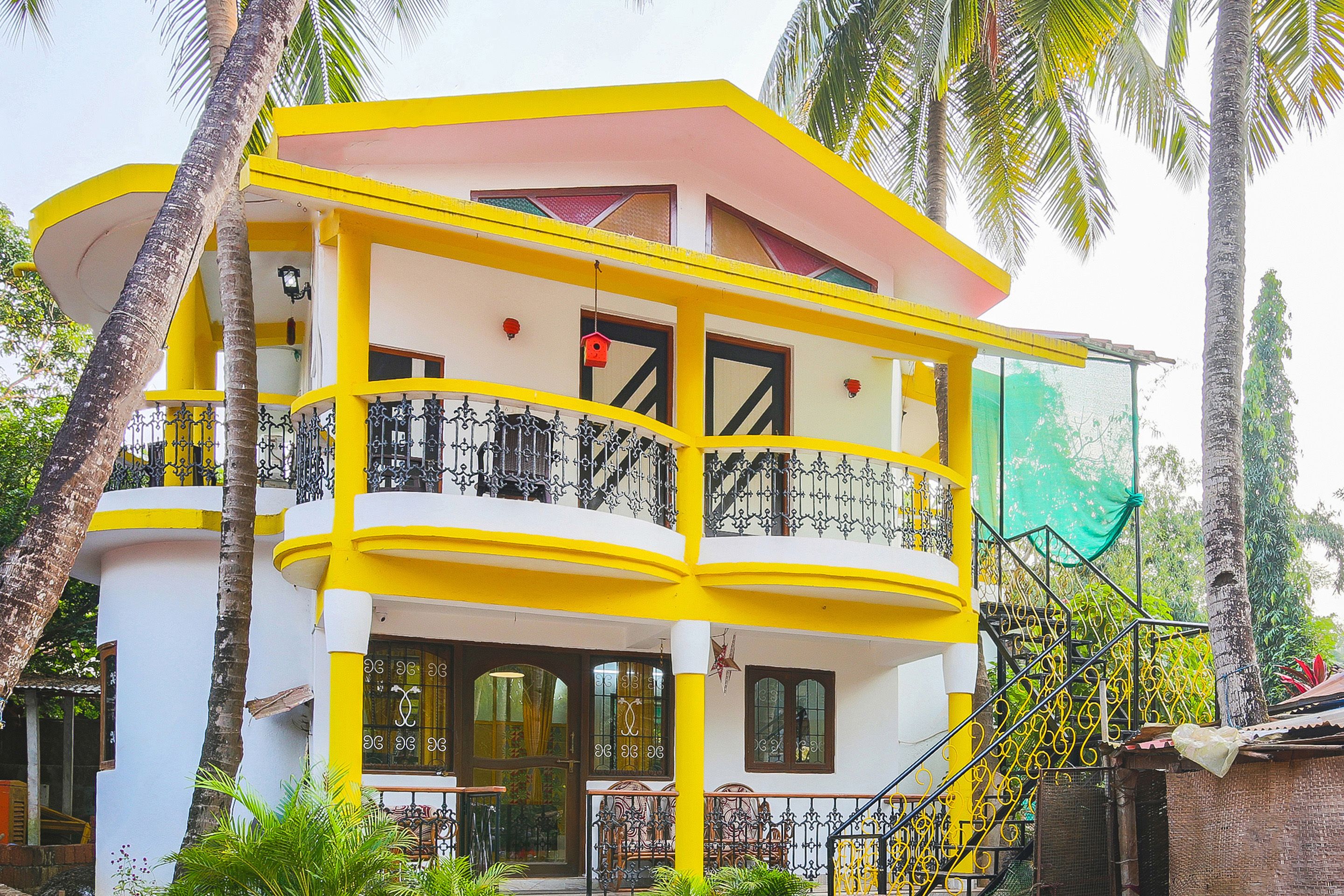 A two-story building with balconies, a staircase, and a green awning.