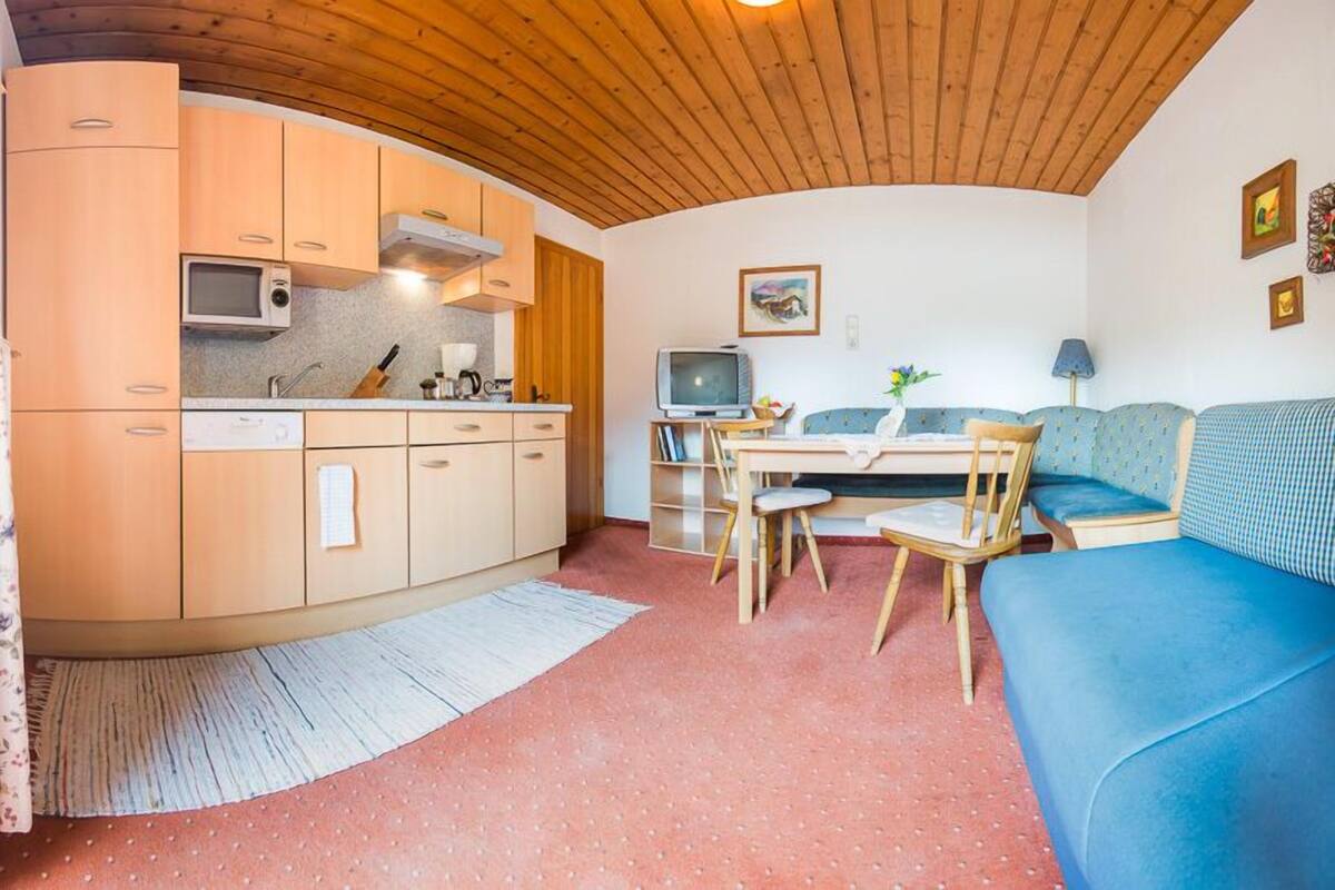 A compact living space with a kitchenette, a dining area, and a seating area.