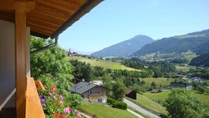 A balcony with a view of a mountain, a church, and a village. - Pension Grubenhof (Fulpmes)
