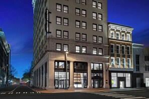 A multi-story building with large windows and a ground-level entrance. - Glass Light Hotel & Gallery, Autograph Collection (Norfolk)