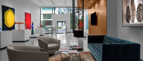 A modern interior with a sofa, chairs, and artwork on the walls.
