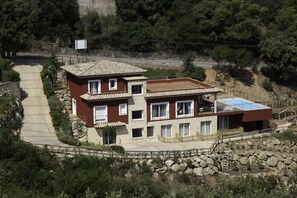 A two-story house with a stone facade, a tiled roof, and a balcony. - Es Cel de Begur Hotel (Begur)