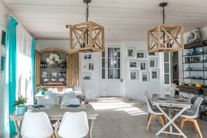 A dining area with wooden tables and chairs, a bar area with shelves, and a wall with framed pictures. - Es Cel de Begur Hotel (Begur)