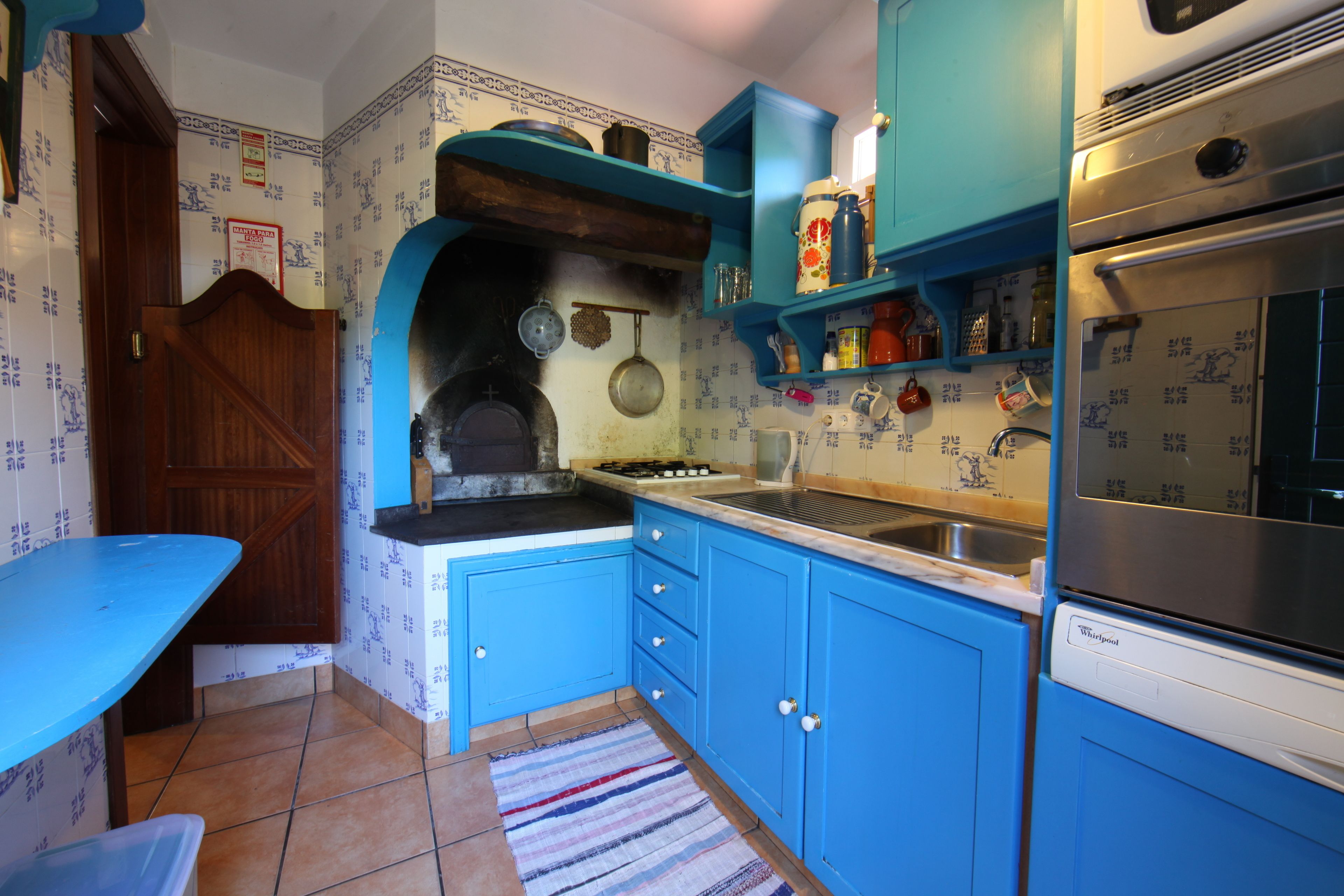 Une cuisine avec des armoires bleues, une cuisinière et un évier.