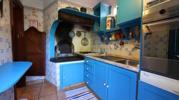 Une cuisine avec des armoires bleues, une cuisinière et un évier.