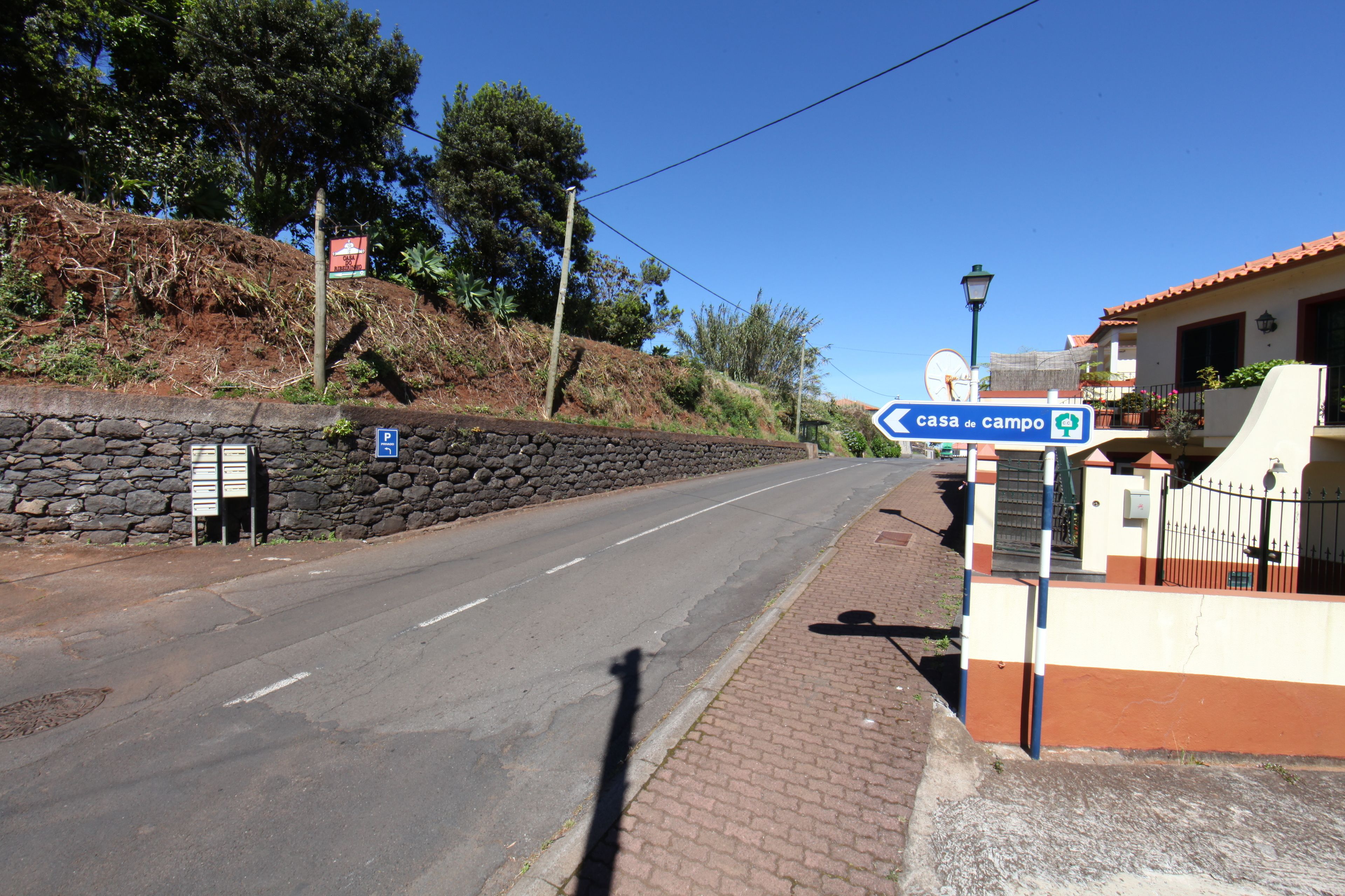 A road leading to a property with a sign indicating 'casa de campo'.