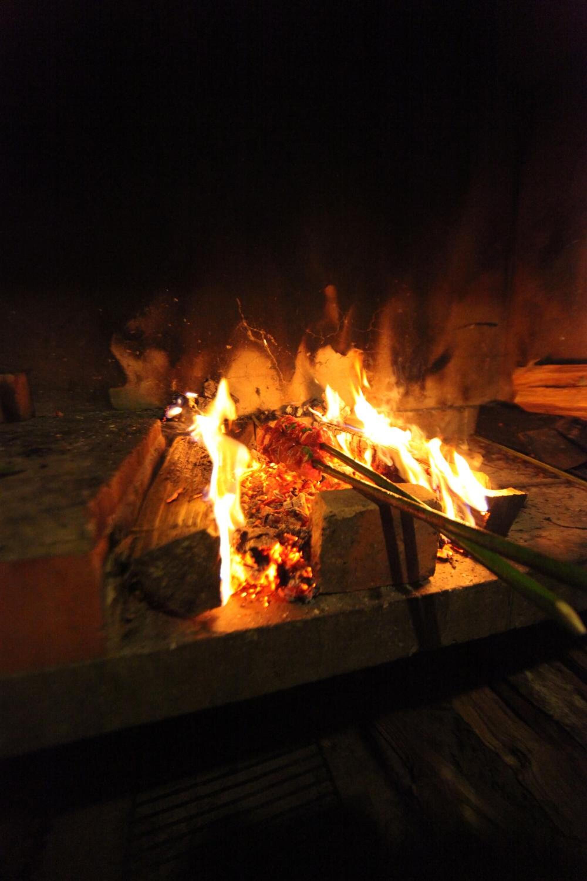 A campfire with logs and burning wood.