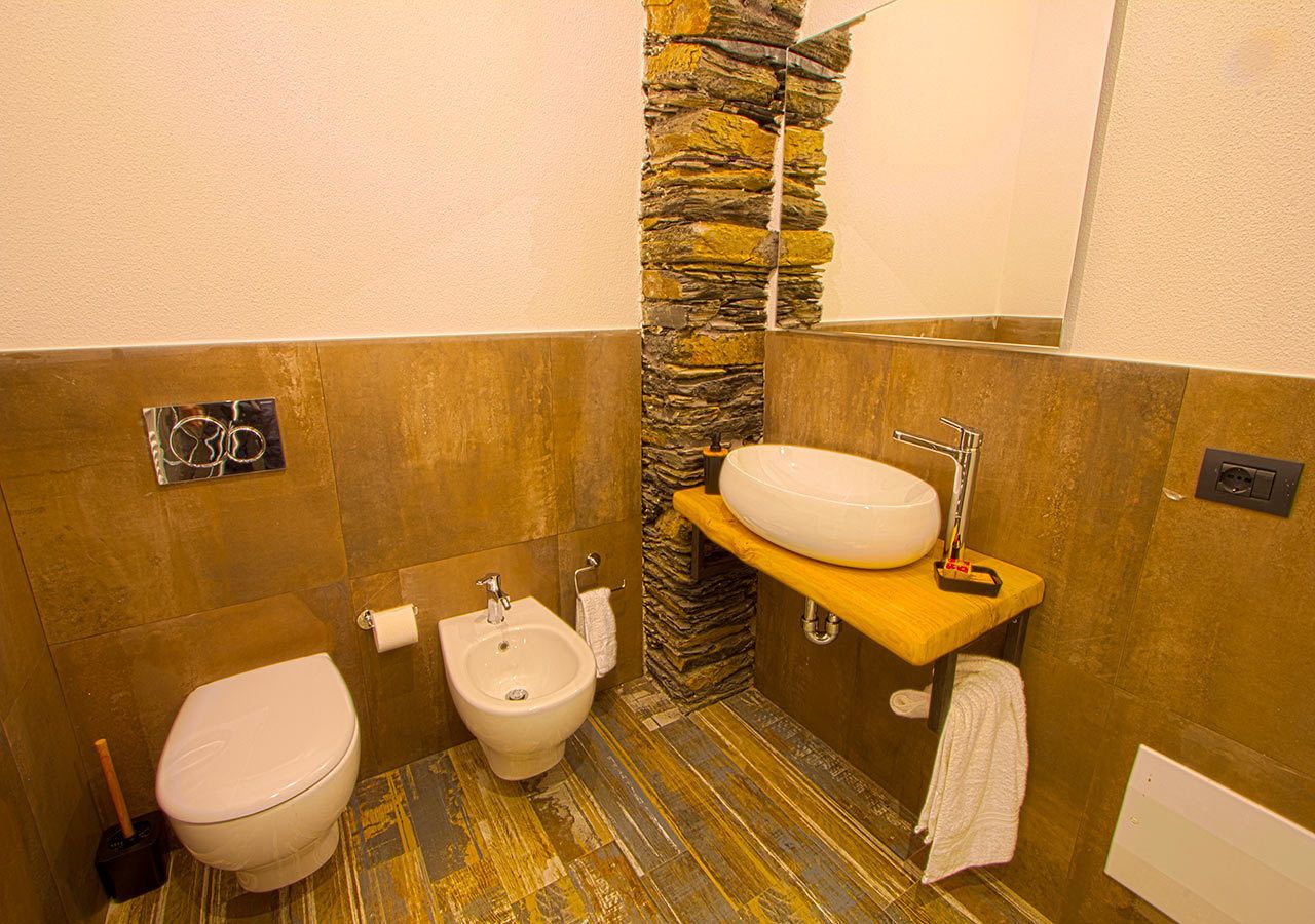 A bathroom with a toilet, bidet, and sink.