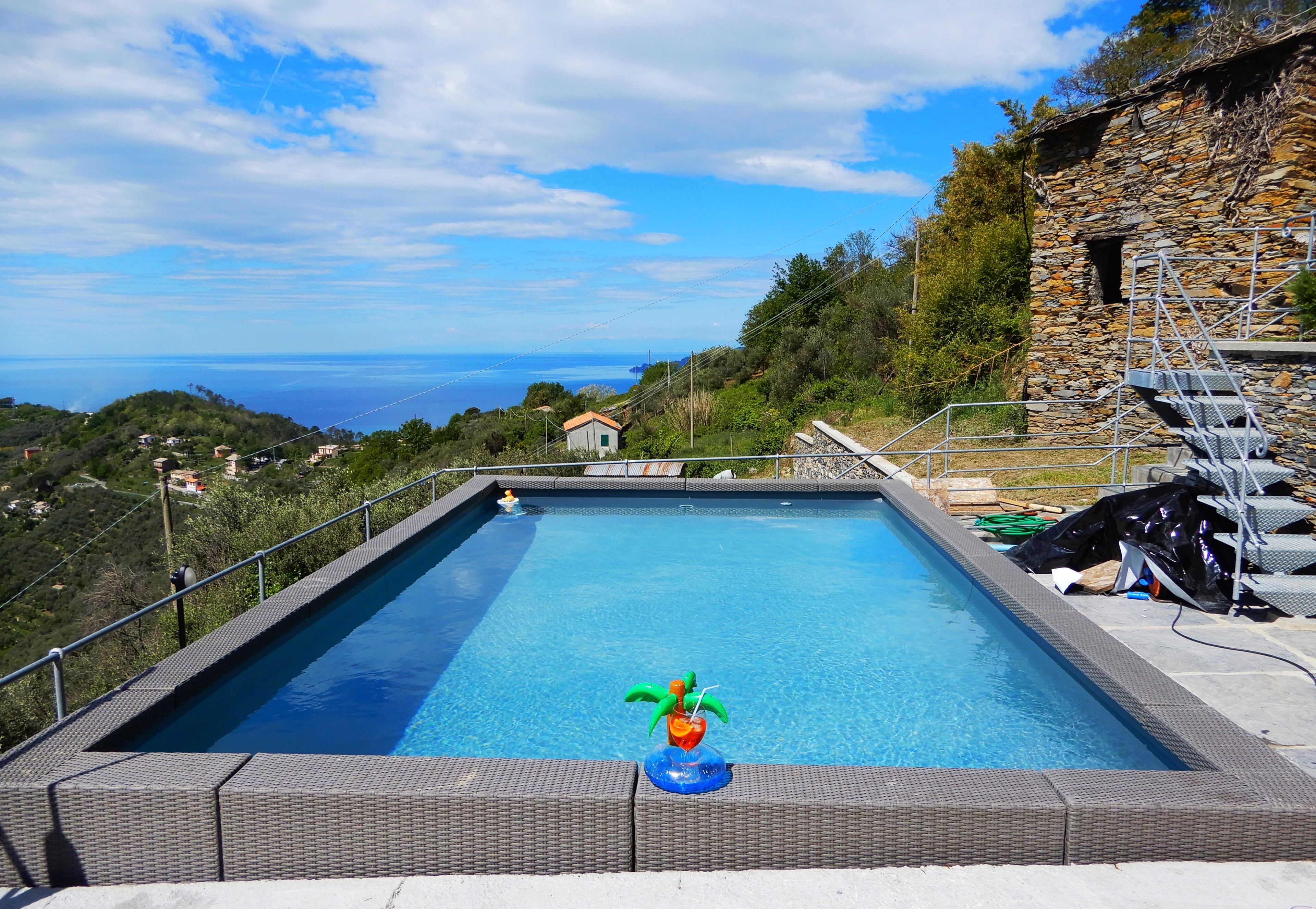 Una piscina al aire libre, sillones reclinables de piscina