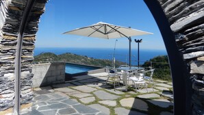 A stone archway leading to a patio with a pool, outdoor furniture, and a view of the sea. - Oltremare Guest House (Lavagna)