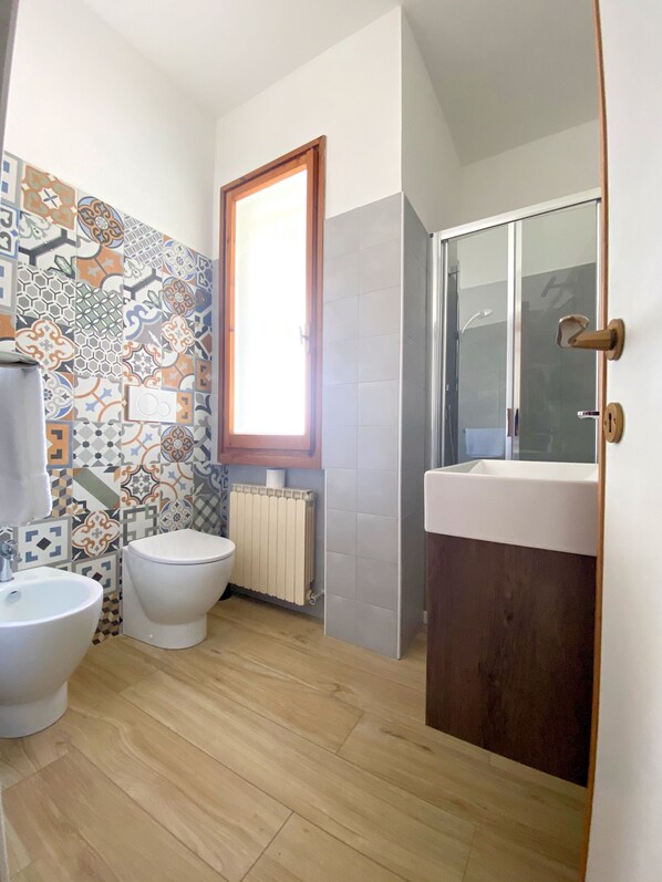 A bathroom with a toilet, bidet, and sink.