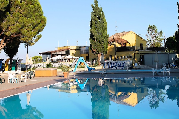 Una piscina al aire libre de temporada, sombrillas